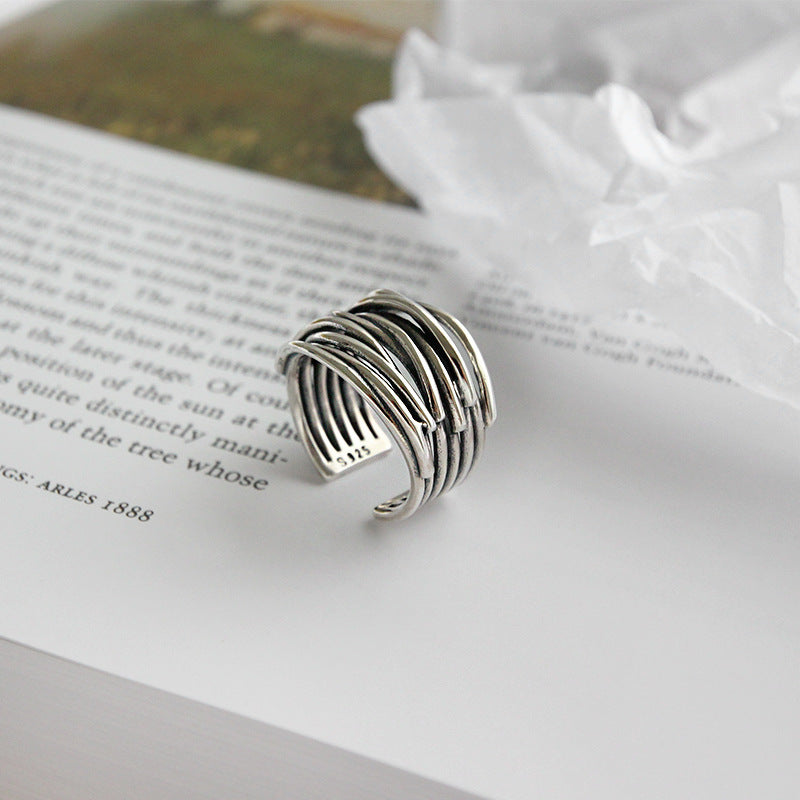 Close-up of a women's sterling silver adjustable layered stacking ring. Chic and modern fashion jewelry.