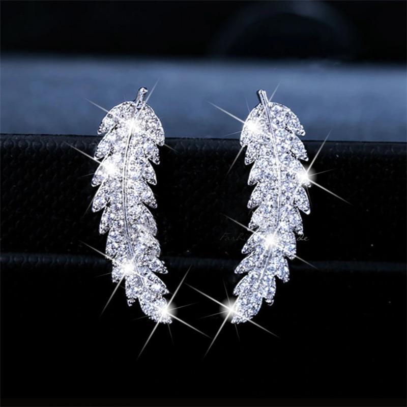 Woman wearing elegant gold plated angel wing sterling silver dangle earrings. Fashion accessory.