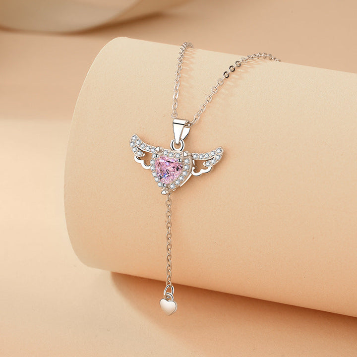 Enchanting angel wings necklace, a women's gold pendant with a shimmering gemstone, unique spiritual jewelry.