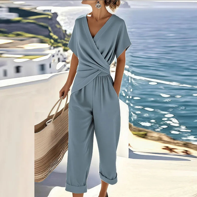 Stylish blue women's wide-leg wrap jumpsuit, ideal for vacation wear or seamless day-to-night elegance.