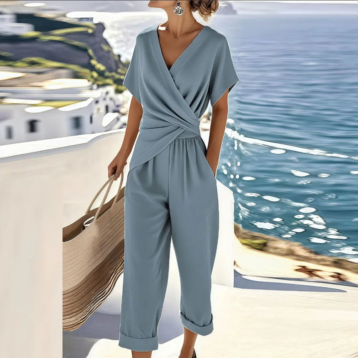 Stylish blue women's wide-leg wrap jumpsuit, ideal for vacation wear or seamless day-to-night elegance.