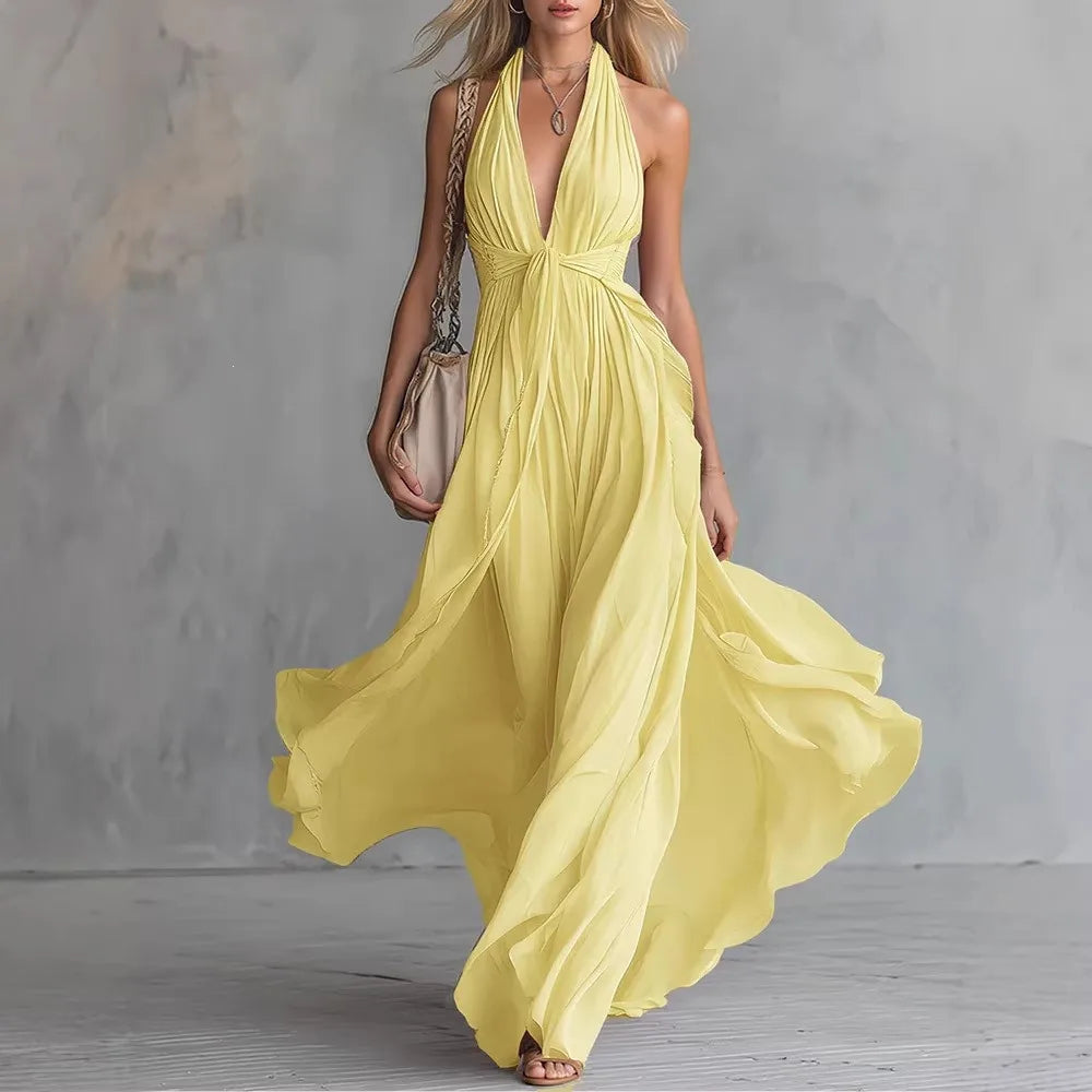 Flowy backless halter maxi dress for women, featuring a pleated side slit. Ideal summer, party or vacation wear.