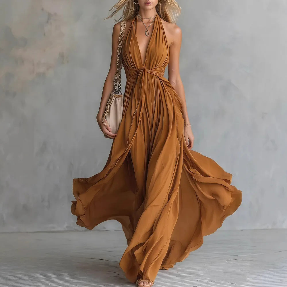 Women's backless halter maxi dress with stylish pleated side slit. An elegant formal or party dress for women.