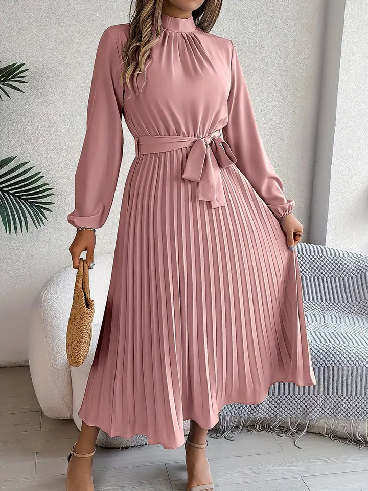 Detail of the flattering belt and intricate pleats on a women's sophisticated midi dress.