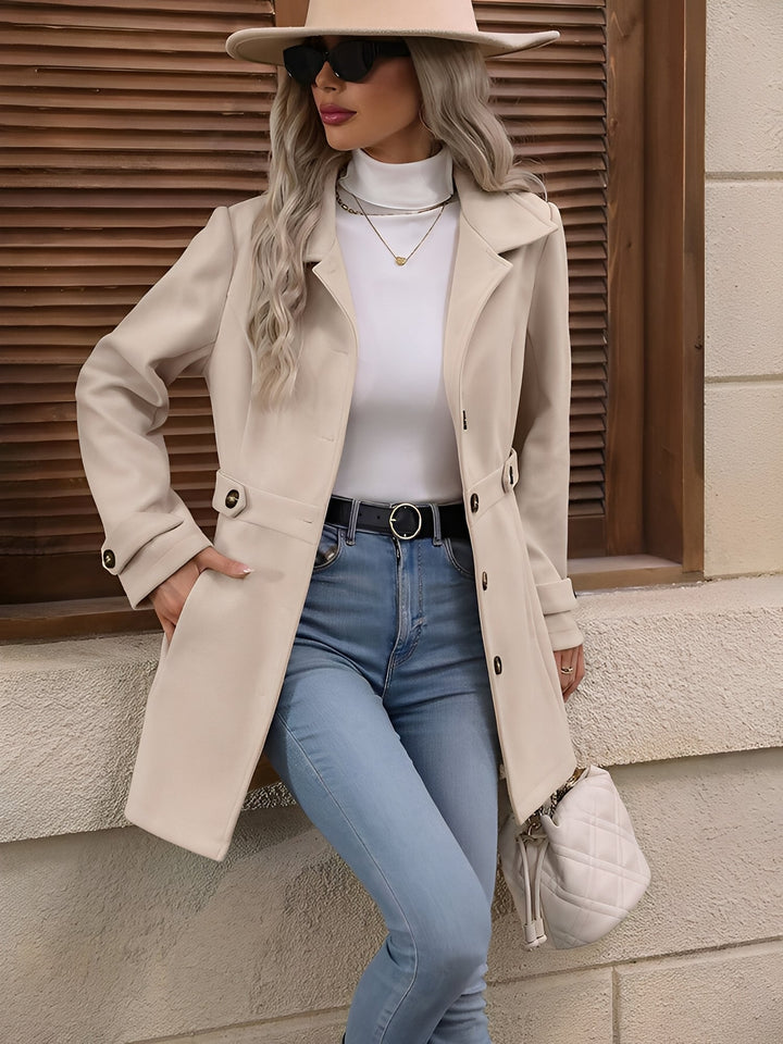 Close-up of the notch collar and double-breasted buttons on a women's classic trench coat.