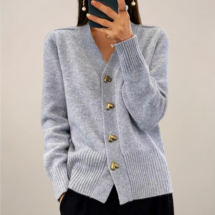 Close-up of elegant gray women's cardigan with shiny gold heart buttons, highlighting the unique detail.