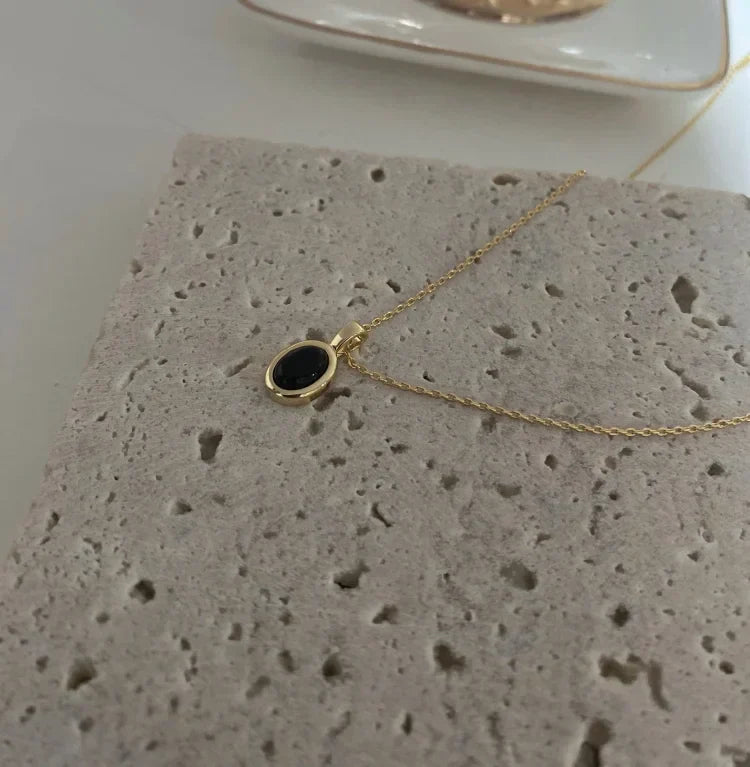 Close-up of elegant women's layered necklace with black onyx beads and delicate freshwater pearls.