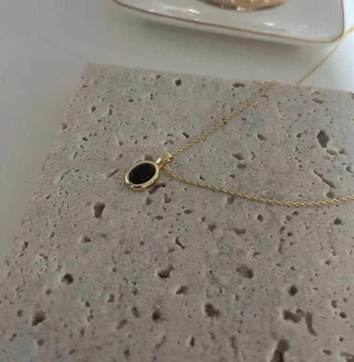 Close-up of elegant women's layered necklace with black onyx beads and delicate freshwater pearls.