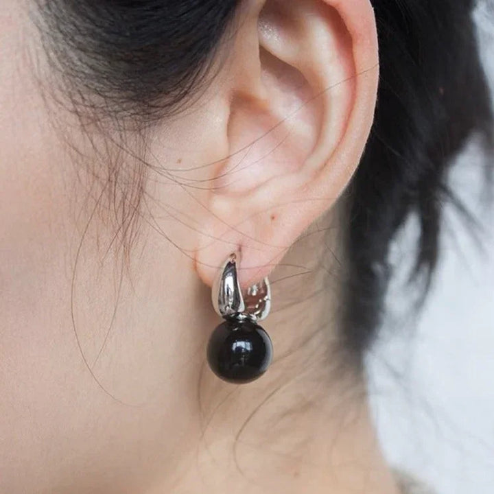 Close-up of elegant black onyx stud earrings, natural gemstone jewelry for women, classic & versatile fashion.