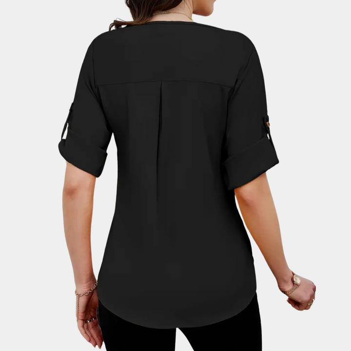 Fashionable women's black blouse featuring elegant pleats, long sleeves, and a loose fit for a chic, versatile look.
