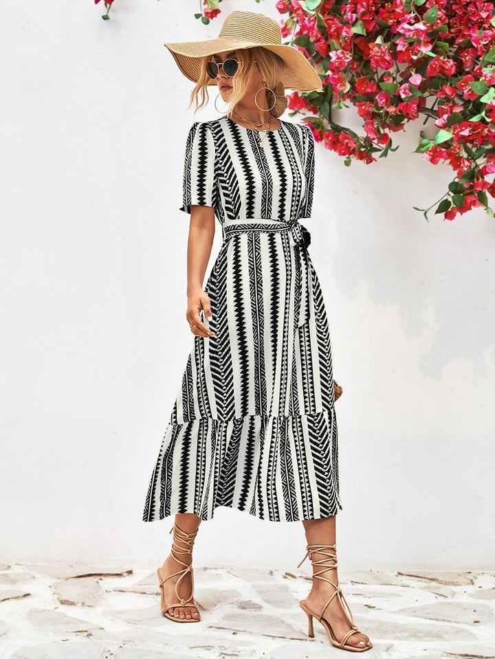 Versatile black & white striped midi dress for women, ideal for elegant office wear or casual summer fashion.