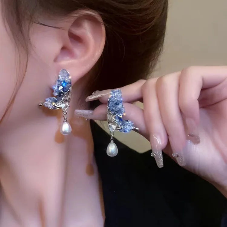 Elegant women's blue crystal butterfly wing pearl drop earrings, perfect for fashion and gifts. Liora jewelry.