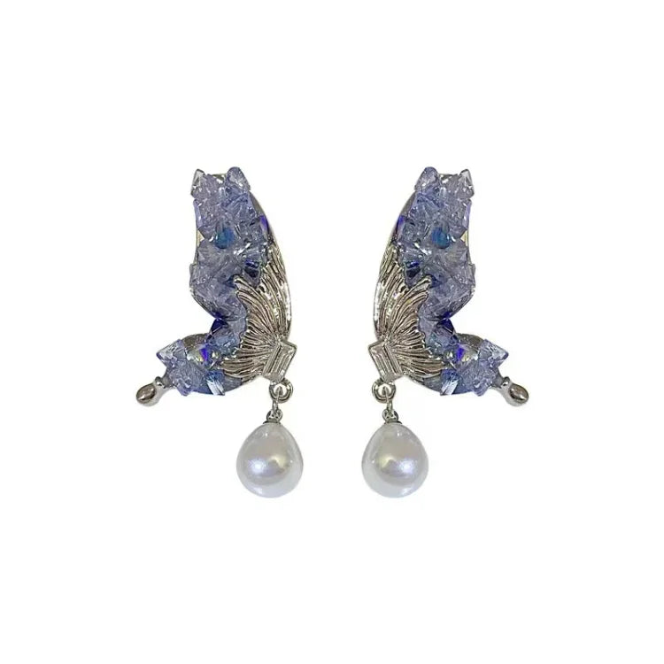 Stunning blue crystal butterfly wing earrings with a delicate pearl drop for women. Stylish jewelry accessory.