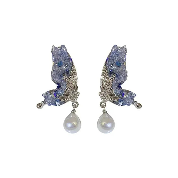 Stunning blue crystal butterfly wing earrings with a delicate pearl drop for women. Stylish jewelry accessory.