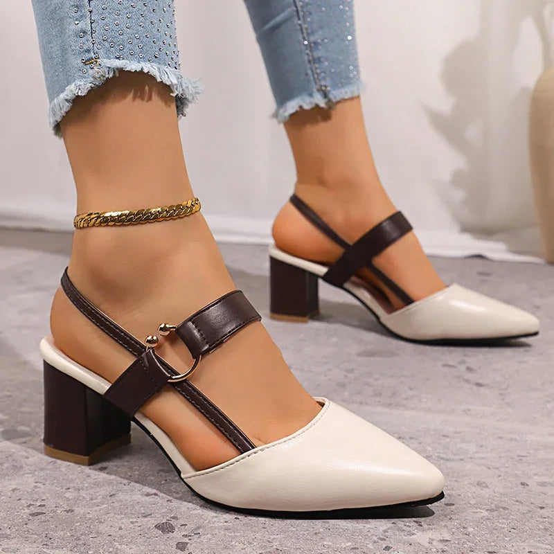 Chic women's slip-on block heels, elegant black footwear with a modern gold ring accent. Fashionable style.