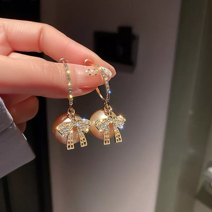 Festive holiday pearl and bow earrings for women, adding a touch of elegance to any Christmas outfit.