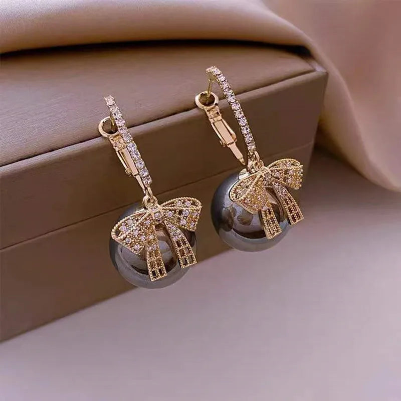 Chic Christmas bow earrings with lustrous pearls, a stylish and festive jewelry gift for women.