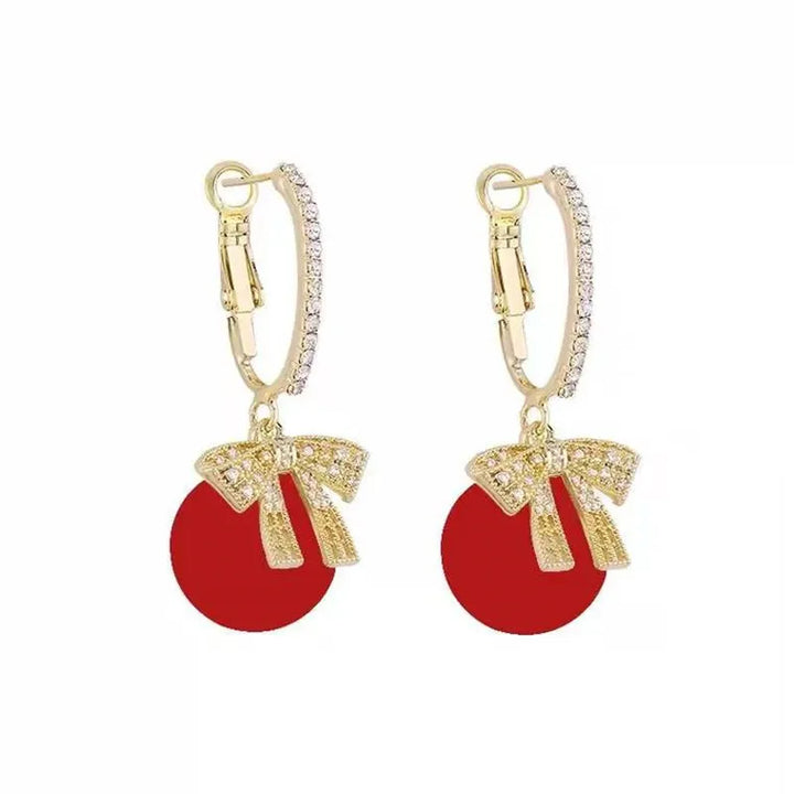 Sparkling women's Christmas jewelry: elegant pearl earrings adorned with festive red bows.