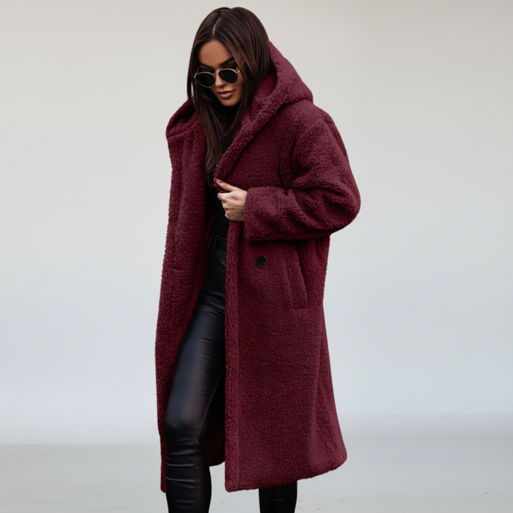 Model posing in a women's elegant longline hooded coat, emphasizing its cozy comfort and stylish design.