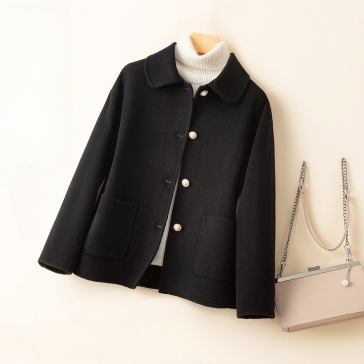 Women's elegant cropped jacket featuring a distinctive doll collar, button closure, and a refined look.