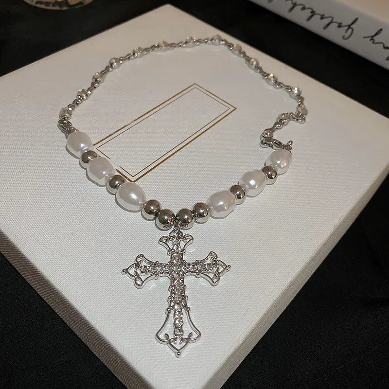 Close-up of an elegant faux pearl cross pendant on a women's fashion necklace, a timeless and dainty accessory.