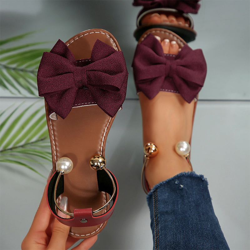 Chic women's flat sandals for casual or elegant looks, featuring a fashionable bow & delicate bead accents.