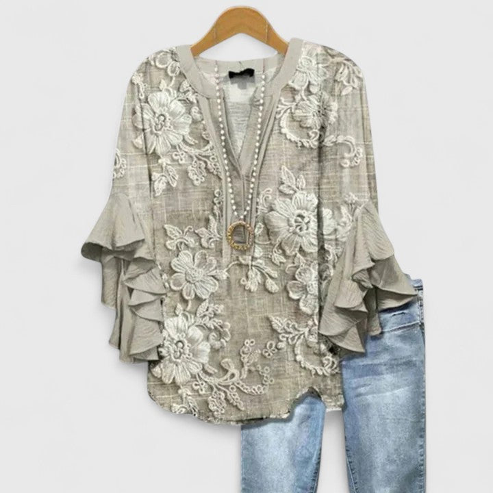 Chic women's floral top with delicate ruffles. Versatile long-sleeve blouse for elegant style.