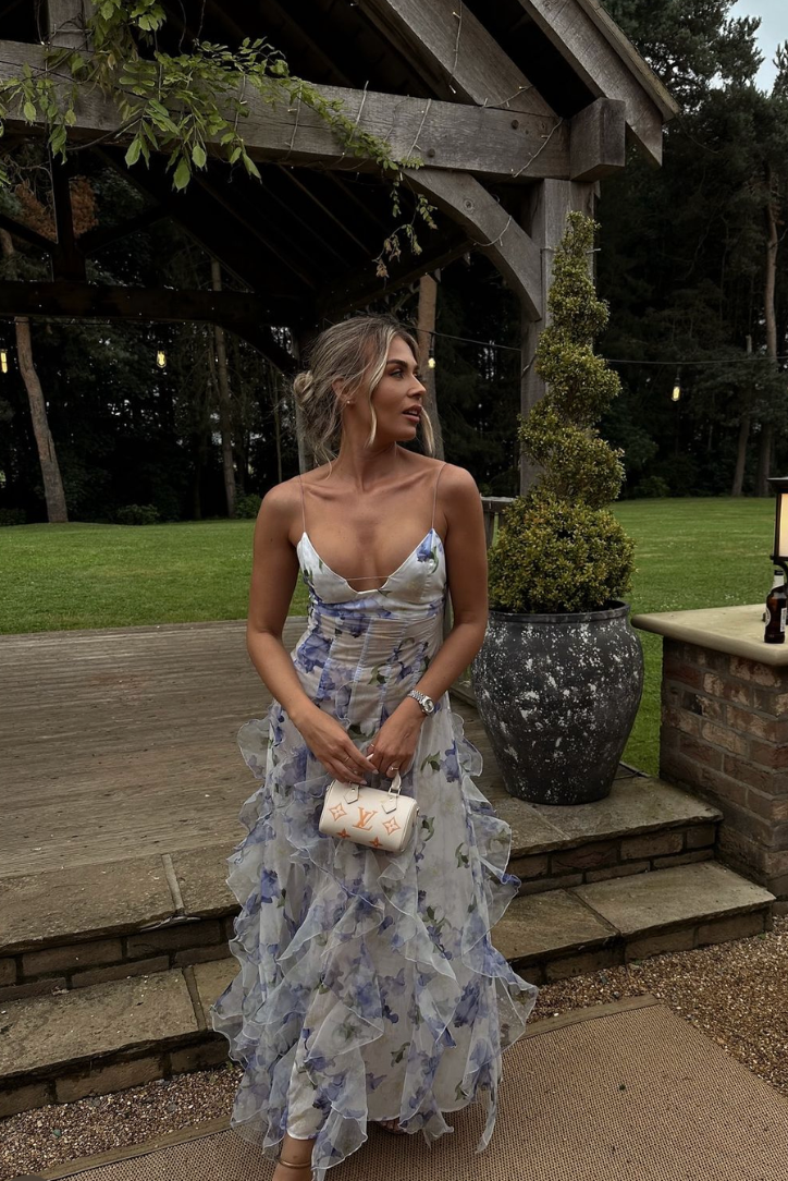 Detailed view of the women's floral print and ruffle trim on this elegant wedding guest maxi dress.