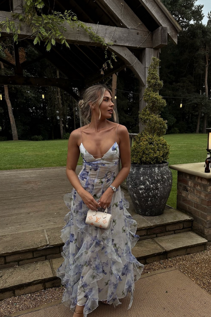 Detailed view of the women's floral print and ruffle trim on this elegant wedding guest maxi dress.