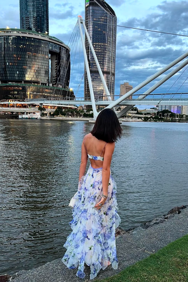 Women's elegant V-neck floral maxi gown featuring a stylish corset and cascading ruffles for events.