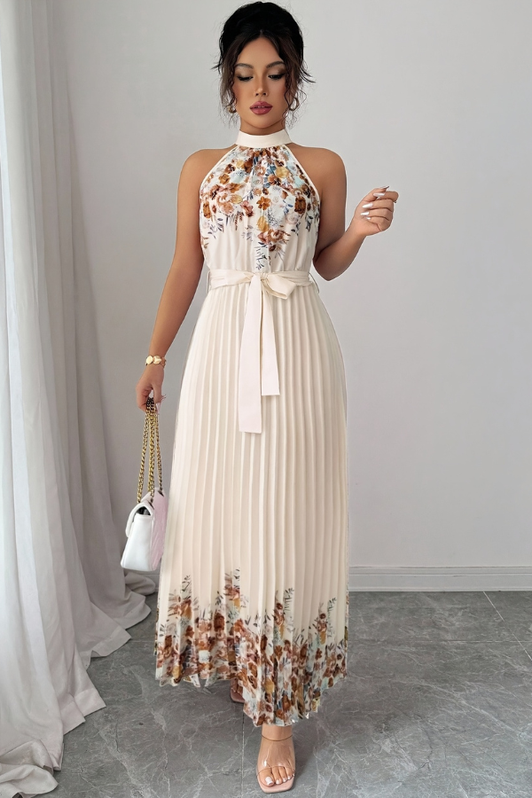 Elegant floral pleated midi dress with square neck, worn outdoors, capturing its summer day charm.