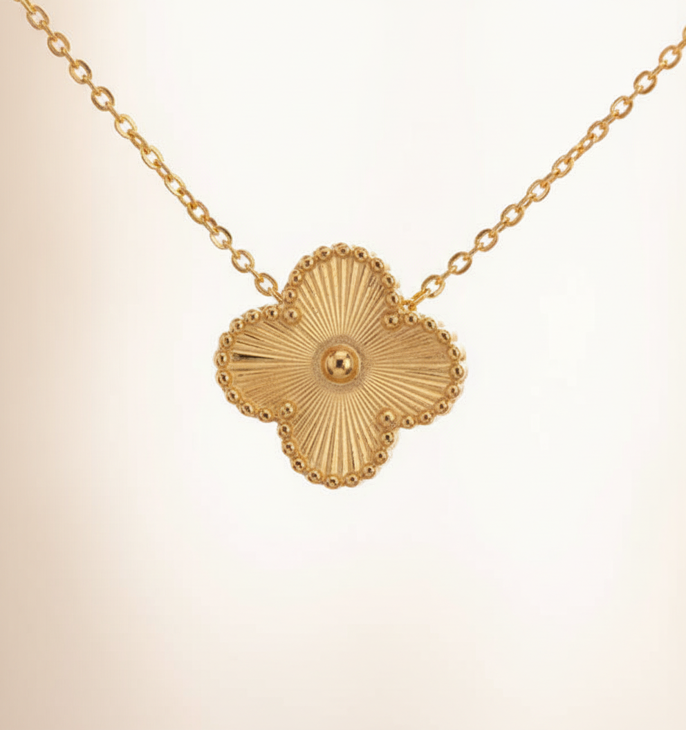 Close-up of a delicate four-leaf clover pendant from the women's necklace and earrings set, fashion jewelry