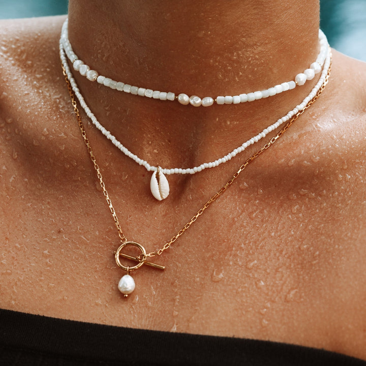 Woman wearing an elegant Freshwater Pearl Necklace (Lucía) with a gold-plated clasp. A beautiful statement jewelry piece.