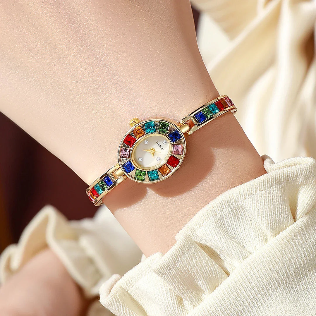 Gold women's gemstone bracelet watch, an elegant fashion accessory with oval dial.