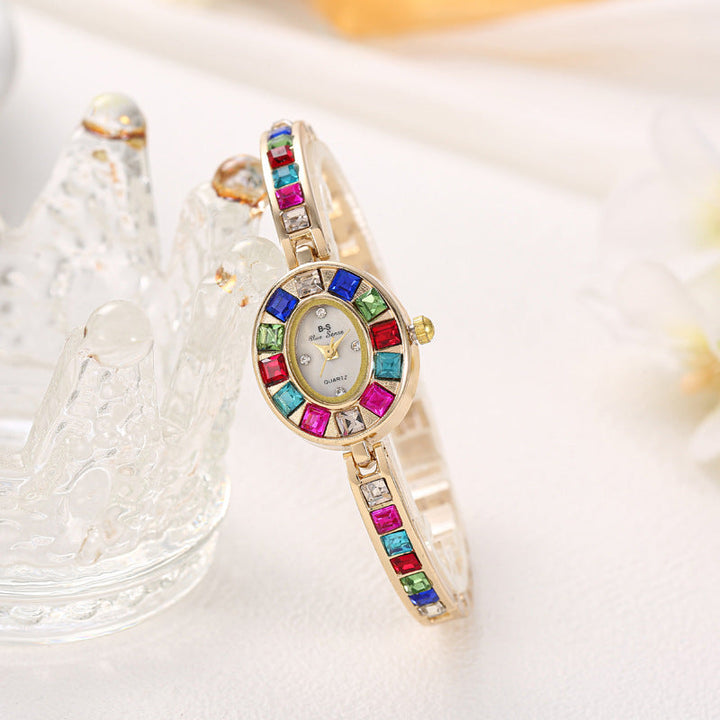 Exquisite gold women's fashion watch, elegant gemstone bracelet with oval dial design.