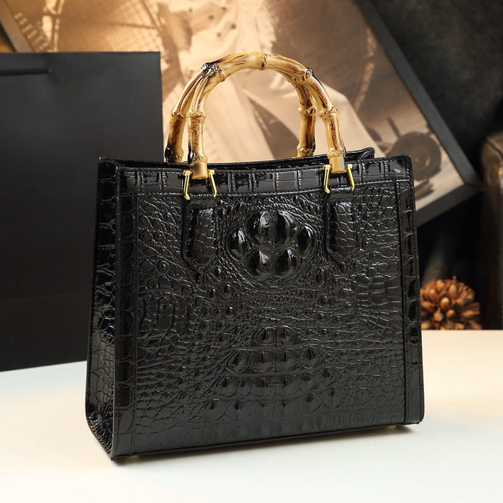 Designer women's genuine leather bag, featuring a luxurious croc pattern and stylish bamboo handle.