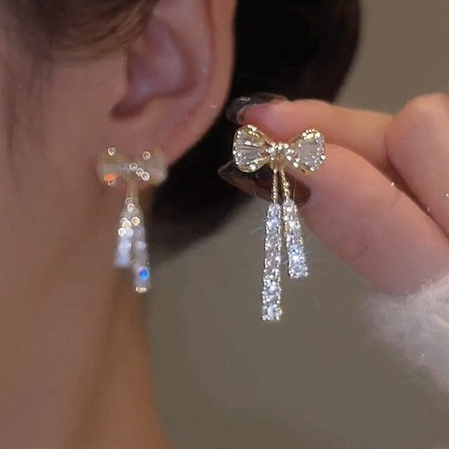 Elegant women's gold bow dangle earrings with sparkling zirconia, perfect jewelry gift.