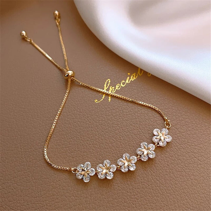 Rosalind luxury gold crystal flower bracelet for women. Elegant floral design with shimmering crystals & a golden finish.