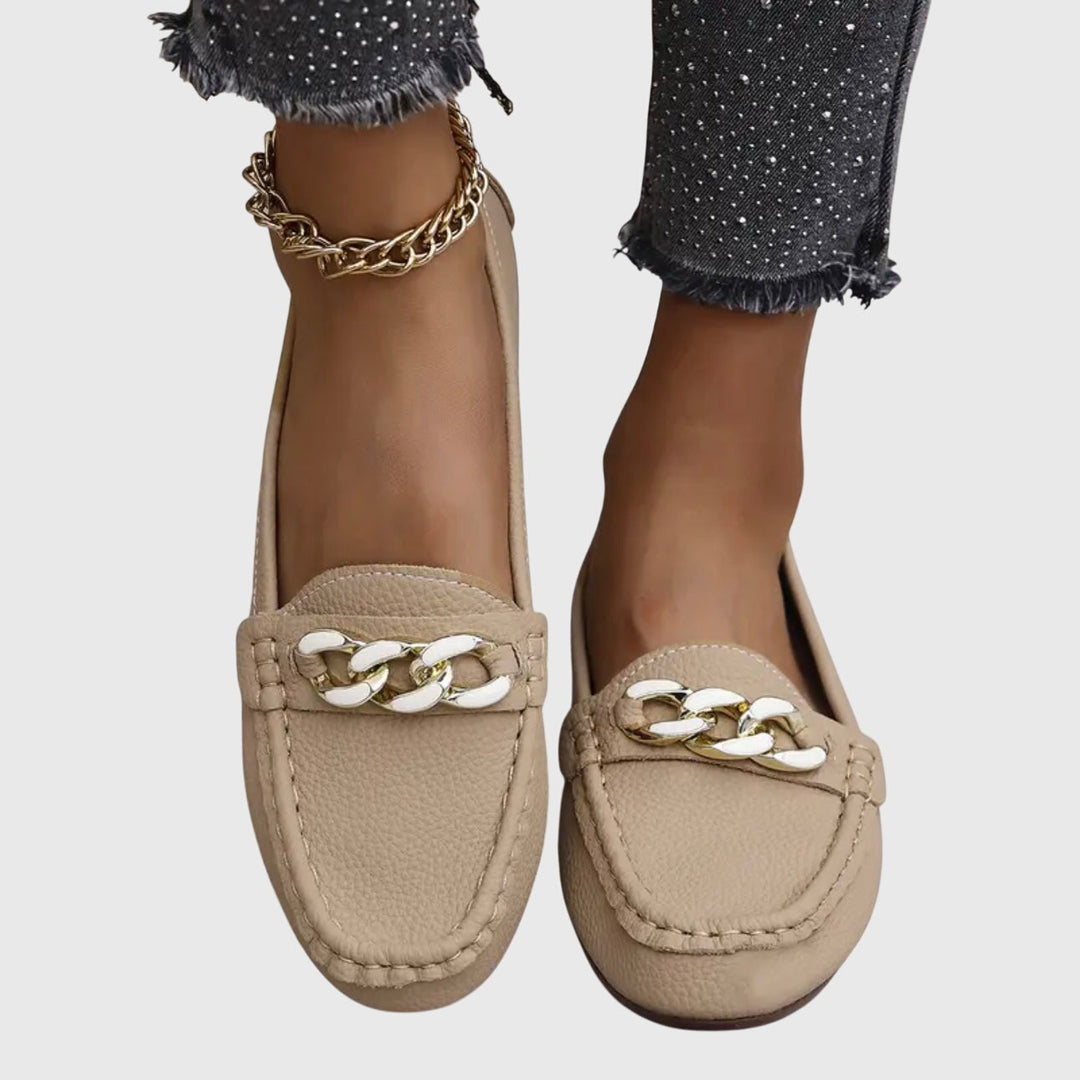 Stylish women's slip-on footwear: wedge loafers with a prominent gold chain detail.