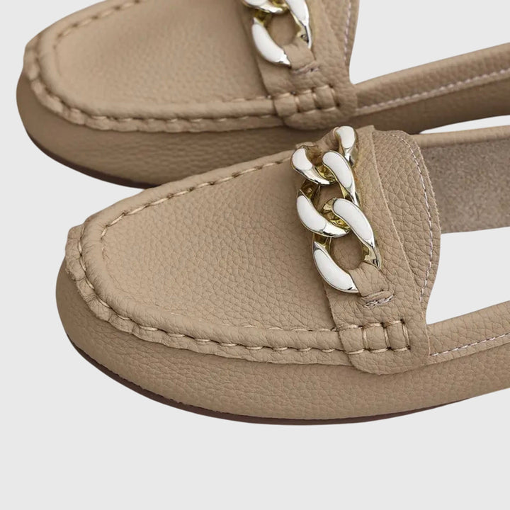 Side profile of elegant women's gold-chain wedge loafers, showcasing the comfortable wedge heel.