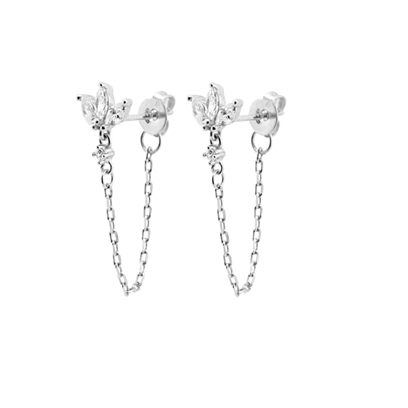 Close-up of elegant gold drop chain earrings with intricate flower detailing & cubic zirconia