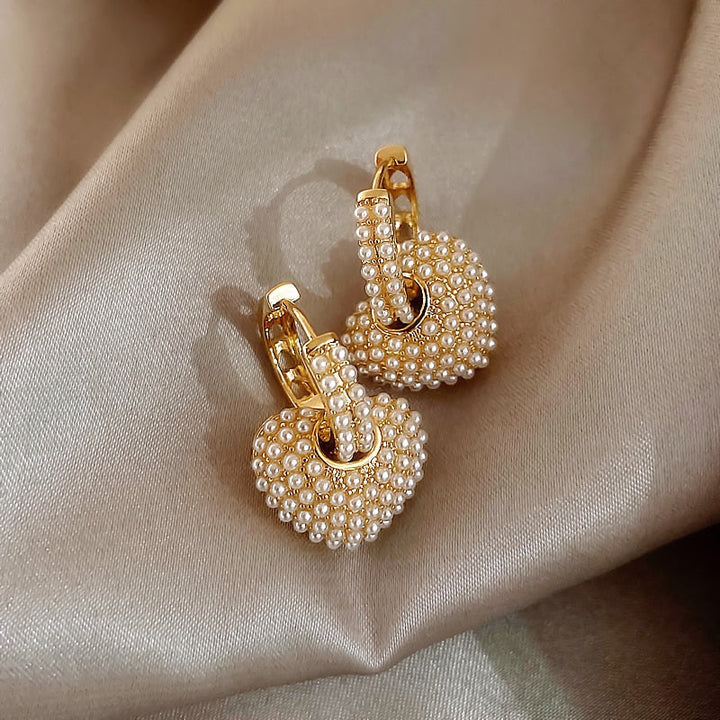 Close-up of stylish gold pearl drop earrings for women, showcasing intricate design and pearls.