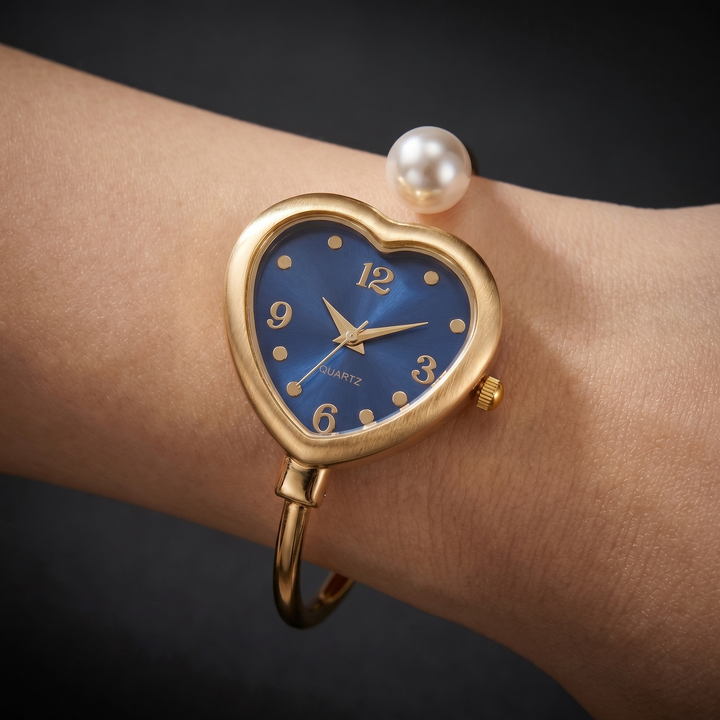 Chic women's gold bracelet watch featuring elegant pearl accents & a subtle heart design. Fashion accessory.