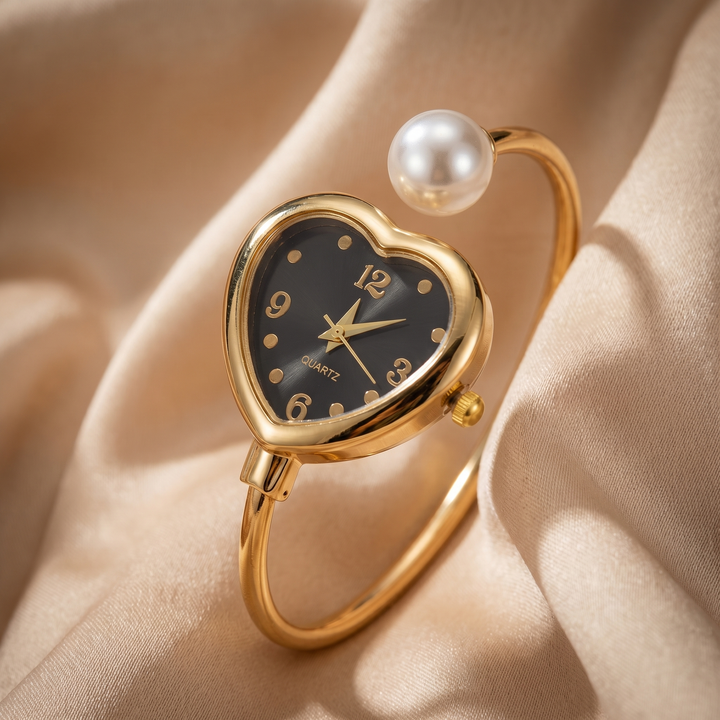 Luxury women's gold tone watch with elegant pearl and heart details. A fashionable bracelet timepiece.