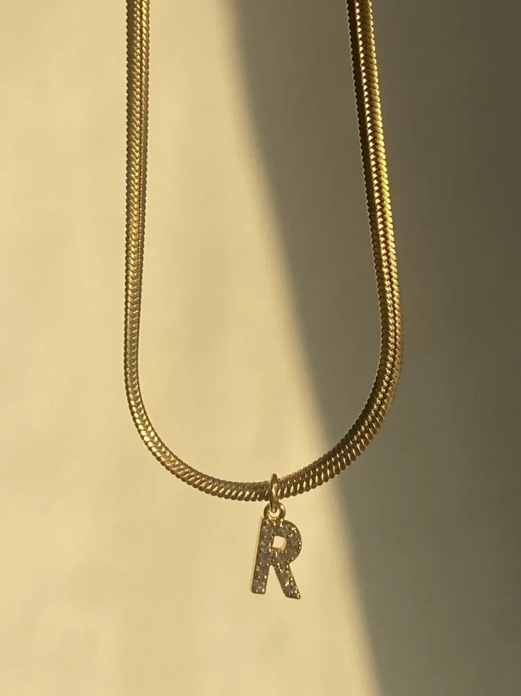 Close-up of a women's personalized gold initial necklace, a chic and elegant custom fashion accessory.