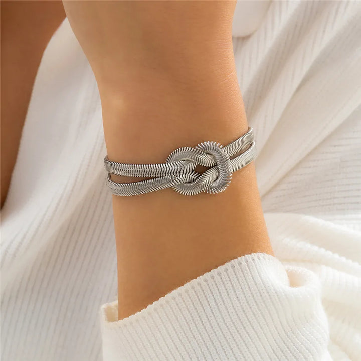 Classic women's gold snake chain bracelet, featuring an elegant knotted design.