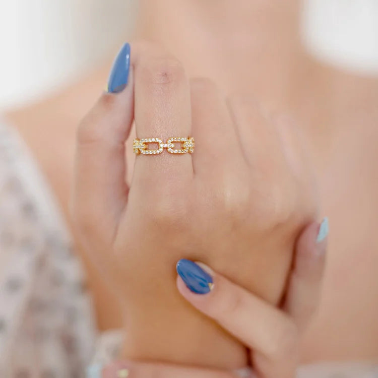 Close-up of a women's gold link ring adorned with shimmering zirconia stones. Elegant and high-quality fashion ring.