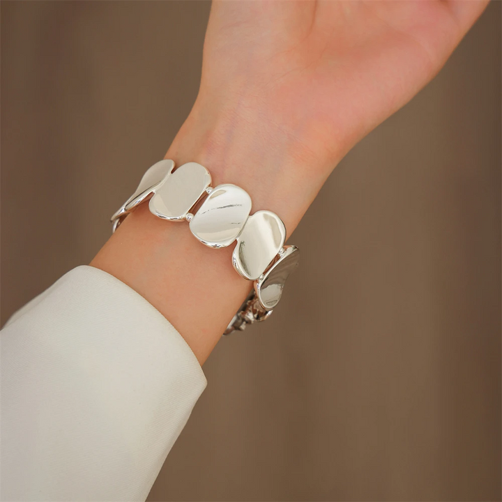 Women's elegant silver sculpted metal smartwatch band, a chic jewelry accessory.