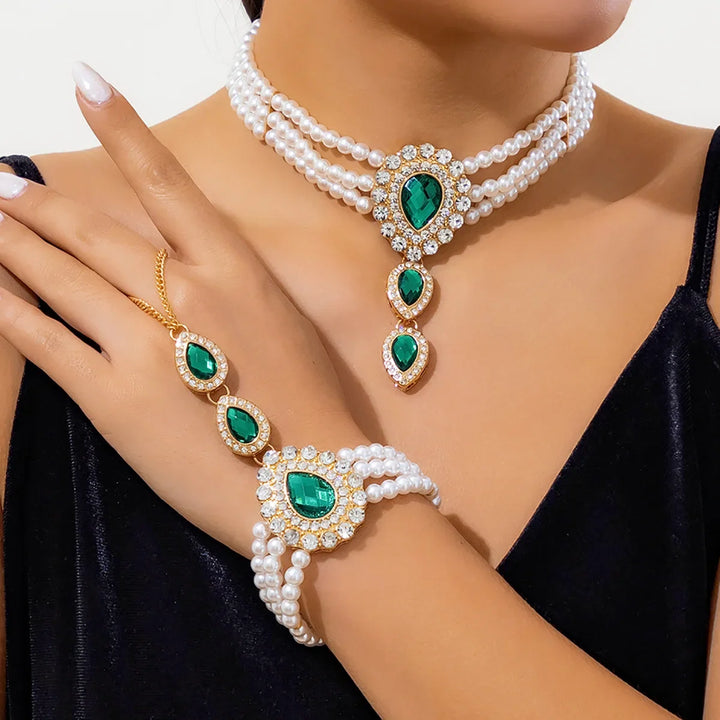 Elegant women's gold pearl & emerald jewelry set featuring a necklace and bracelet, perfect as a fashion accessory.