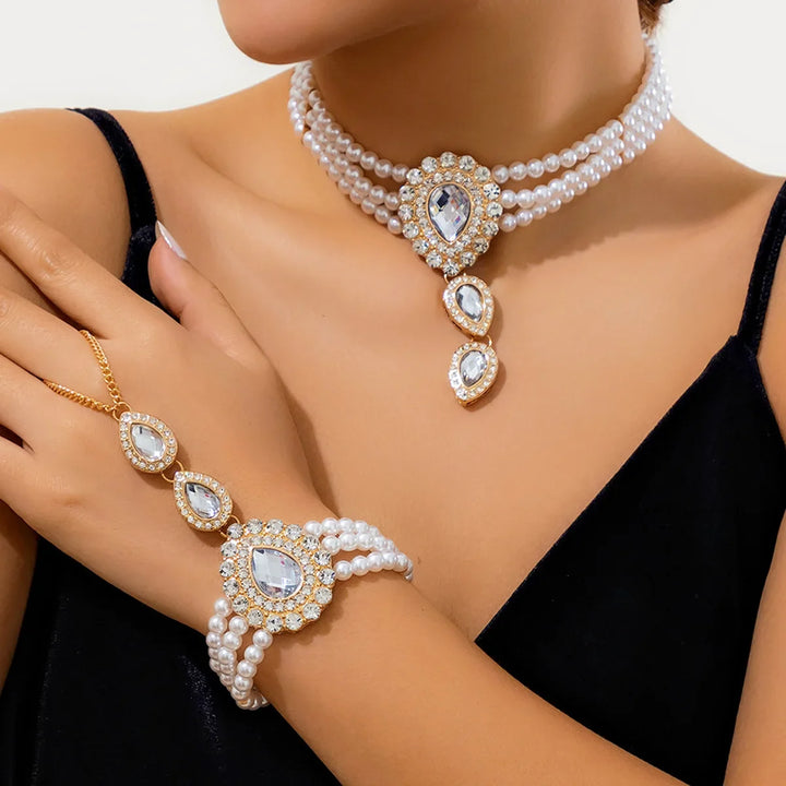 Stunning gold necklace from a women's jewelry set, adorned with lustrous pearls and vibrant emeralds. Statement piece.